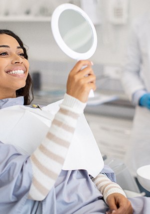 Woman smiling while looking at reflection in mirror